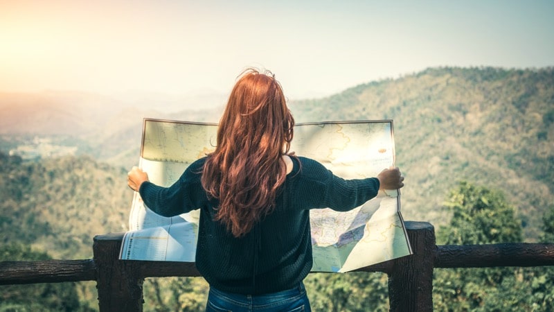 Woman looking out and holding a map