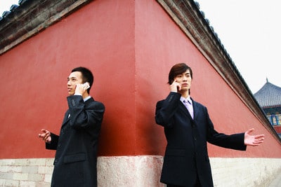 Two Chinese men talking on the phone